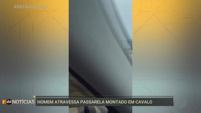 Homem atravessa passarela montado em cavalo